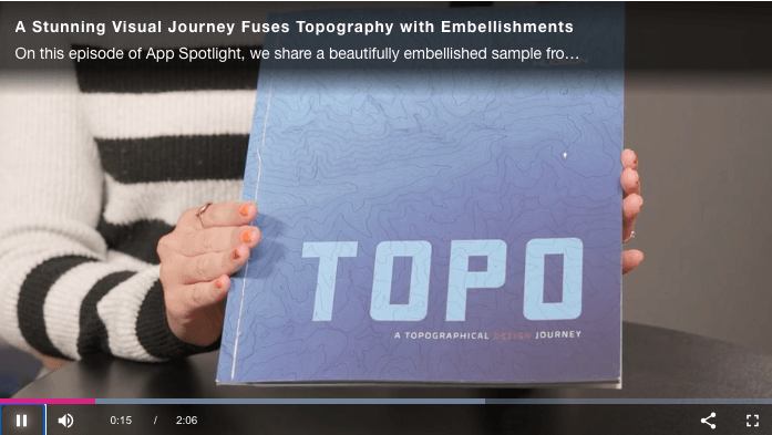 Screenshot of video where Ashley Roberts holds up the magazine titled TOPO which features the possibilities of embellishment in print.